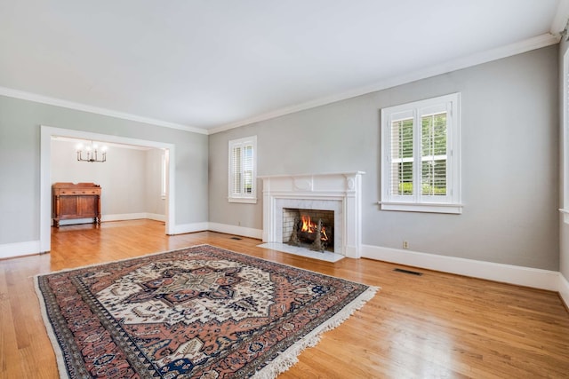 living room with a tiled fireplace, ornamental molding, and hardwood / wood-style floors