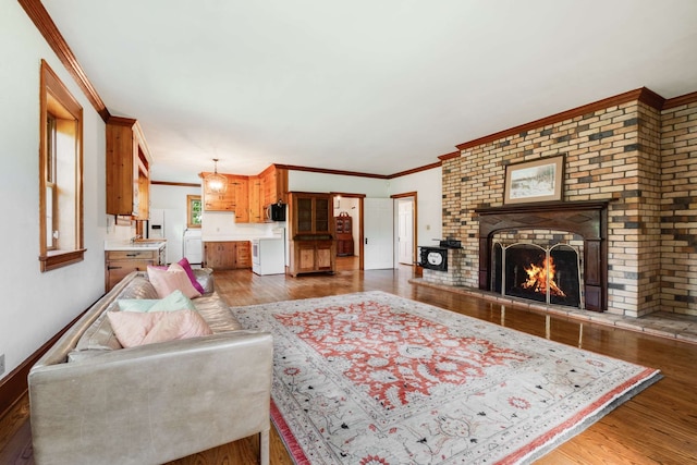 living room featuring crown molding, hardwood / wood-style flooring, and a fireplace