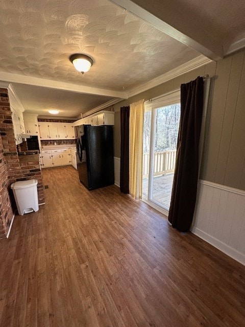 unfurnished living room with brick wall, dark hardwood / wood-style flooring, and ornamental molding