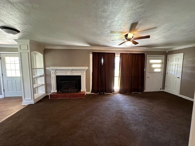 unfurnished living room featuring ceiling fan, dark carpet, a fireplace, and a textured ceiling