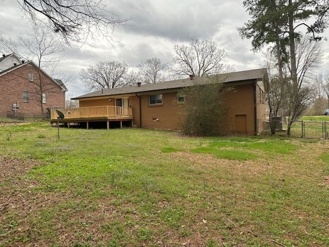 rear view of property with a lawn and a deck