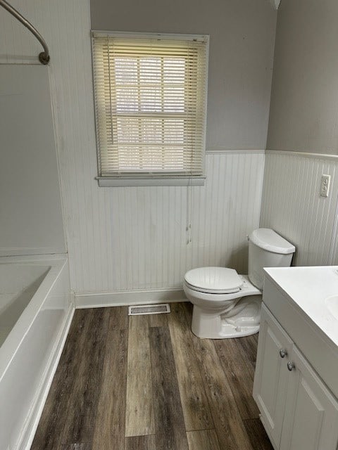 full bathroom with toilet, vanity, bathing tub / shower combination, and hardwood / wood-style flooring