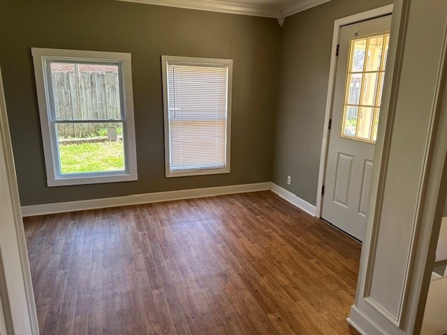 unfurnished room with ornamental molding and dark wood-type flooring