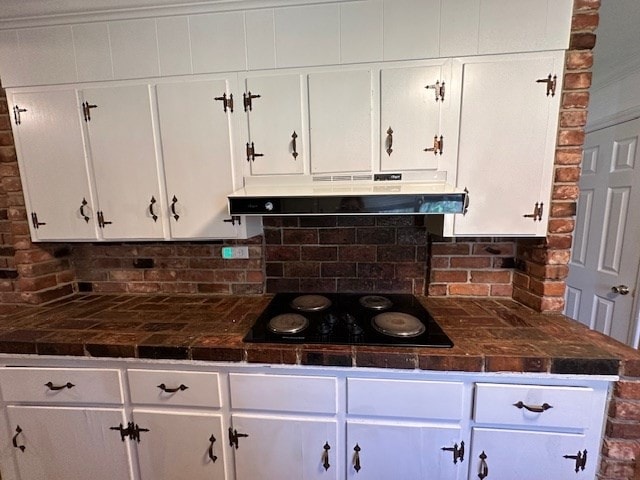 kitchen with black electric cooktop, tasteful backsplash, extractor fan, and white cabinetry