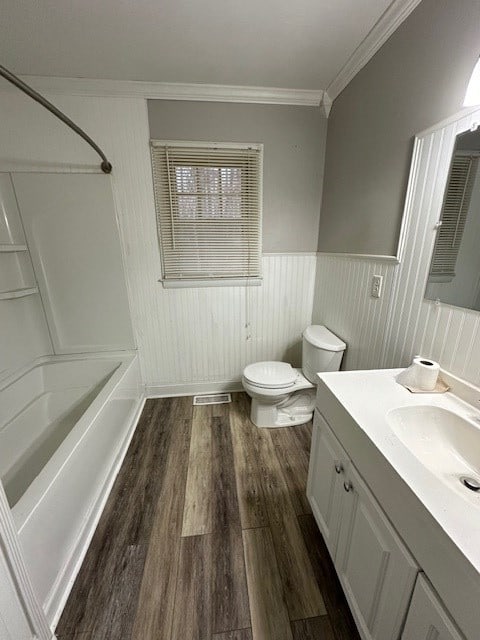 full bathroom featuring vanity, hardwood / wood-style floors, shower / tub combination, toilet, and ornamental molding