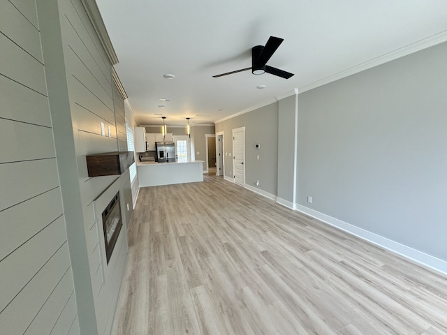 unfurnished living room with ceiling fan, ornamental molding, and light hardwood / wood-style flooring