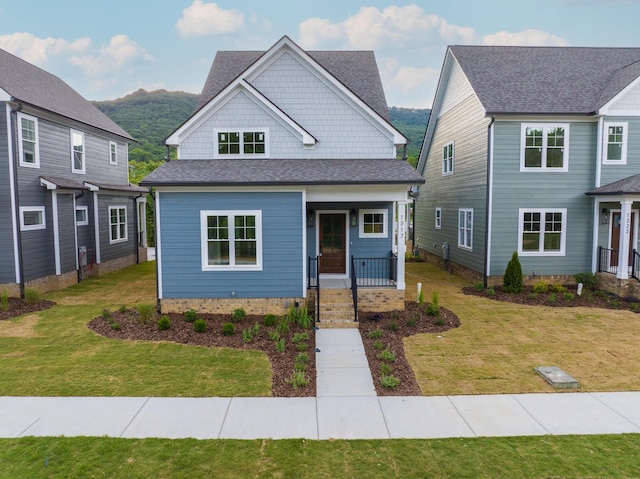 view of front of property with a front yard, a porch, and a mountain view