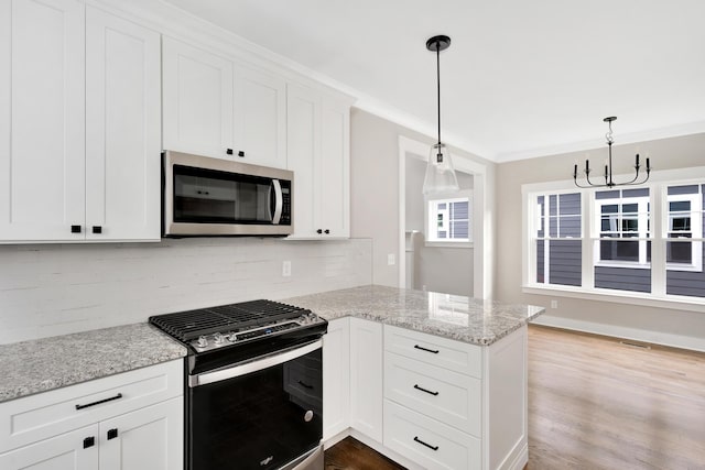 kitchen with kitchen peninsula, decorative light fixtures, stainless steel appliances, a notable chandelier, and white cabinetry