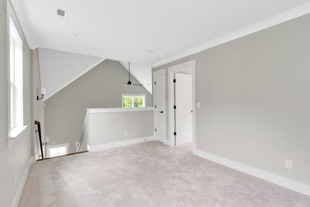 carpeted spare room featuring vaulted ceiling, ceiling fan, and crown molding