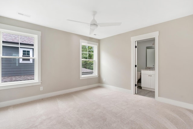 carpeted spare room featuring ceiling fan