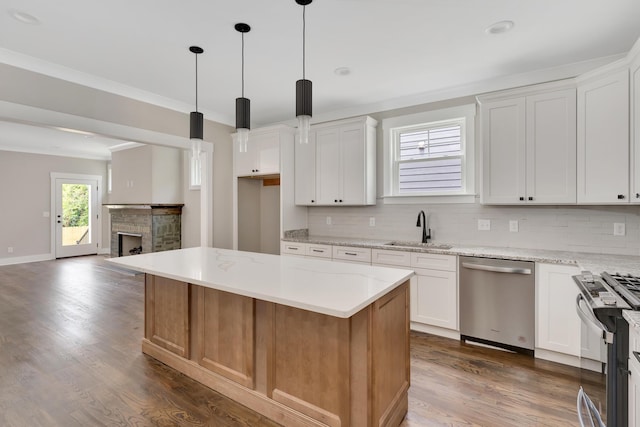 kitchen with appliances with stainless steel finishes, white cabinetry, and a center island