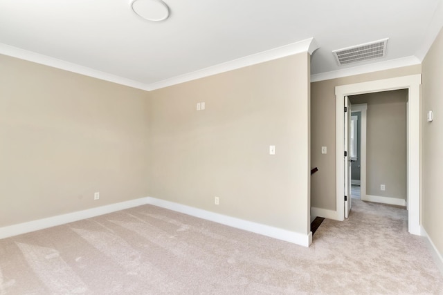 spare room with baseboards, visible vents, crown molding, and light colored carpet