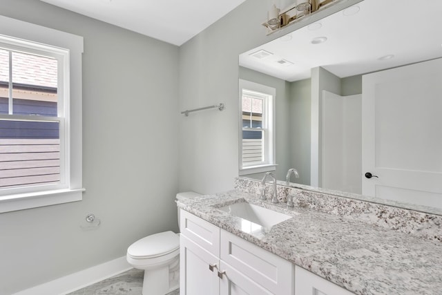 half bathroom featuring baseboards, vanity, and toilet