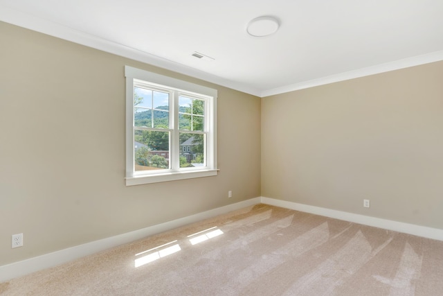 unfurnished room featuring ornamental molding, light carpet, visible vents, and baseboards