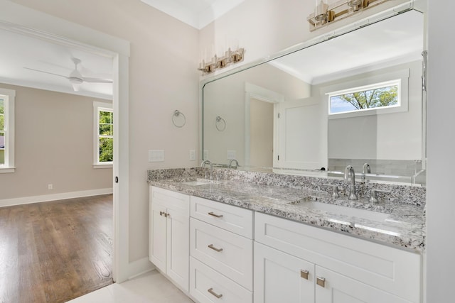 full bath with double vanity, plenty of natural light, and a sink