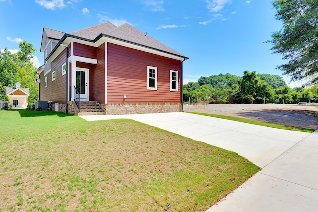 view of property exterior featuring driveway, a shingled roof, cooling unit, and a lawn