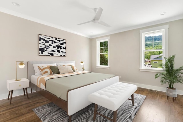 bedroom with baseboards, dark wood-style flooring, and crown molding