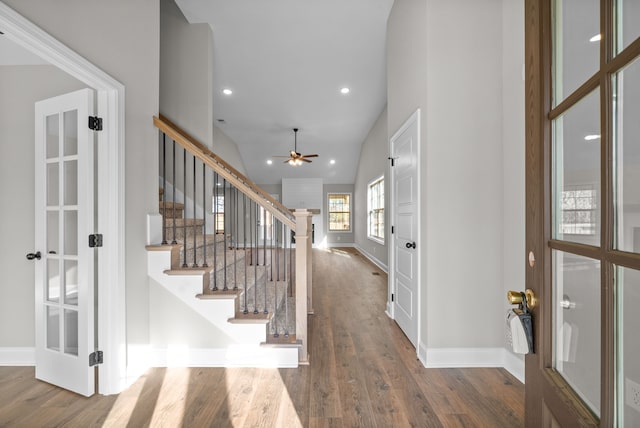 entrance foyer with ceiling fan, vaulted ceiling, wood-type flooring, and french doors