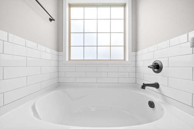 bathroom with a wealth of natural light and a washtub