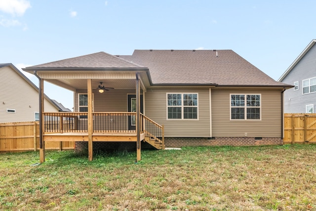 back of property with ceiling fan, a yard, and a wooden deck