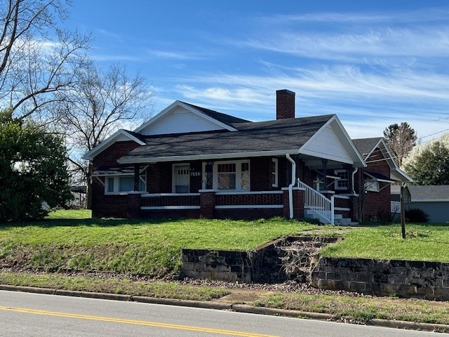 view of front of home featuring covered porch and a front lawn