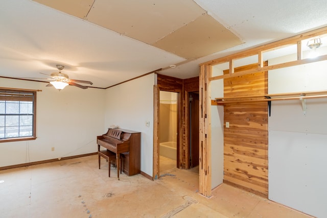 misc room with wooden walls and ceiling fan