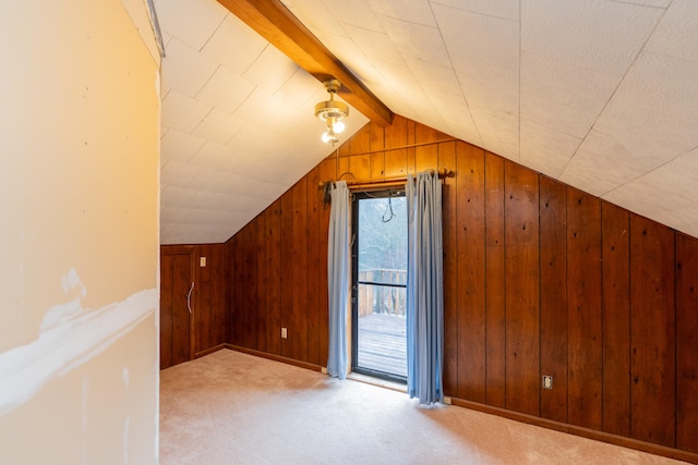 additional living space with vaulted ceiling with beams, wood walls, and light carpet