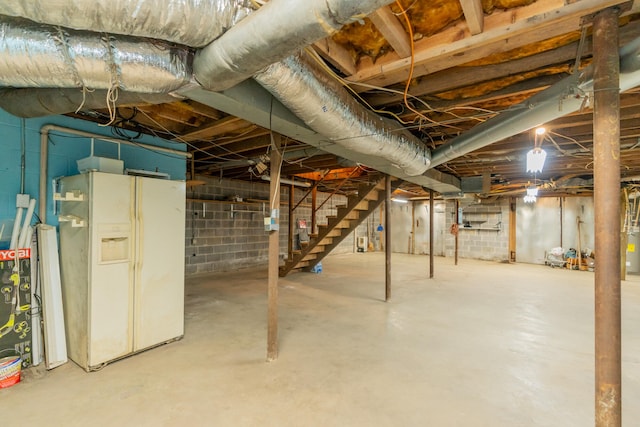 basement with white refrigerator with ice dispenser