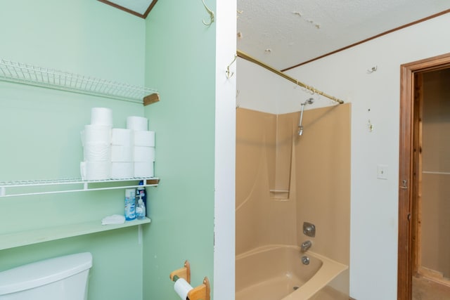 bathroom with toilet, shower / bath combination, and a textured ceiling