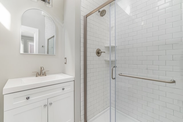 bathroom featuring vanity and a shower with shower door