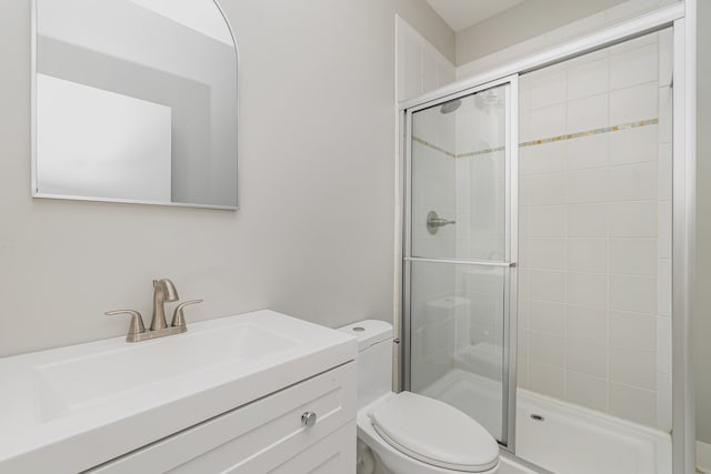 bathroom featuring an enclosed shower, vanity, and toilet