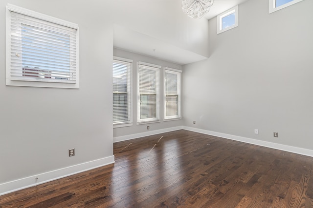 unfurnished room with dark hardwood / wood-style flooring and a healthy amount of sunlight