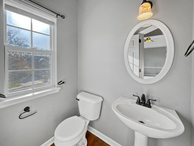 bathroom with hardwood / wood-style flooring, sink, ceiling fan, and toilet