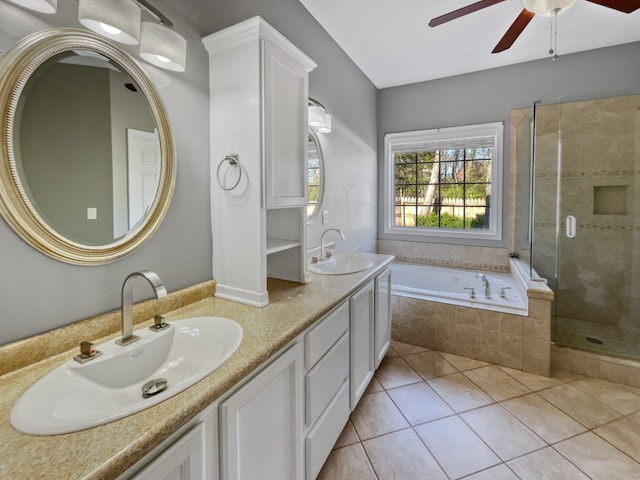 bathroom with large vanity, double sink, ceiling fan, tile flooring, and plus walk in shower