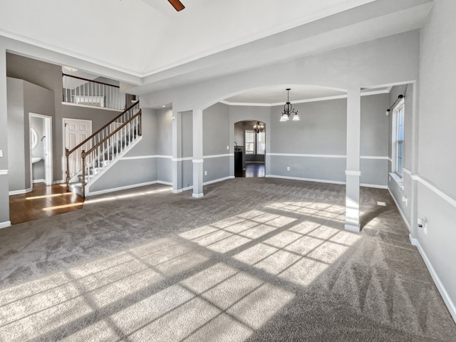 carpeted spare room featuring ceiling fan with notable chandelier and ornamental molding