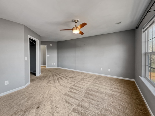 carpeted empty room with ceiling fan and a healthy amount of sunlight