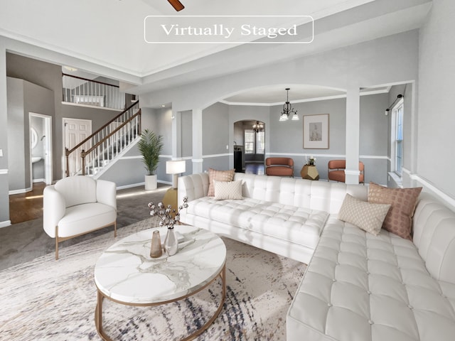 living room featuring crown molding and ceiling fan with notable chandelier