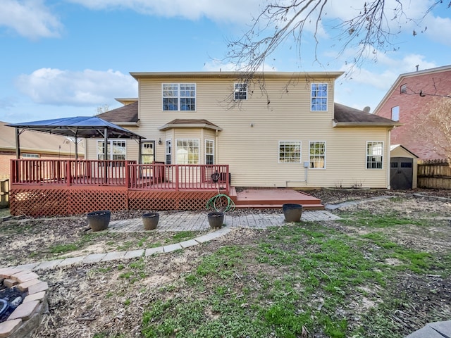 back of property with a deck and a gazebo