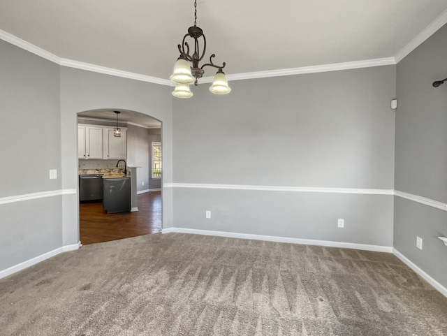 unfurnished room with an inviting chandelier, crown molding, and dark carpet