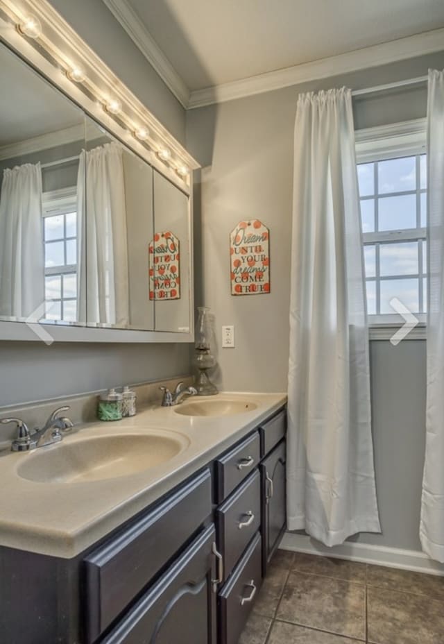 bathroom with ornamental molding, tile patterned floors, and double vanity