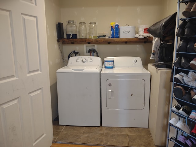 clothes washing area with washing machine and dryer and tile patterned flooring