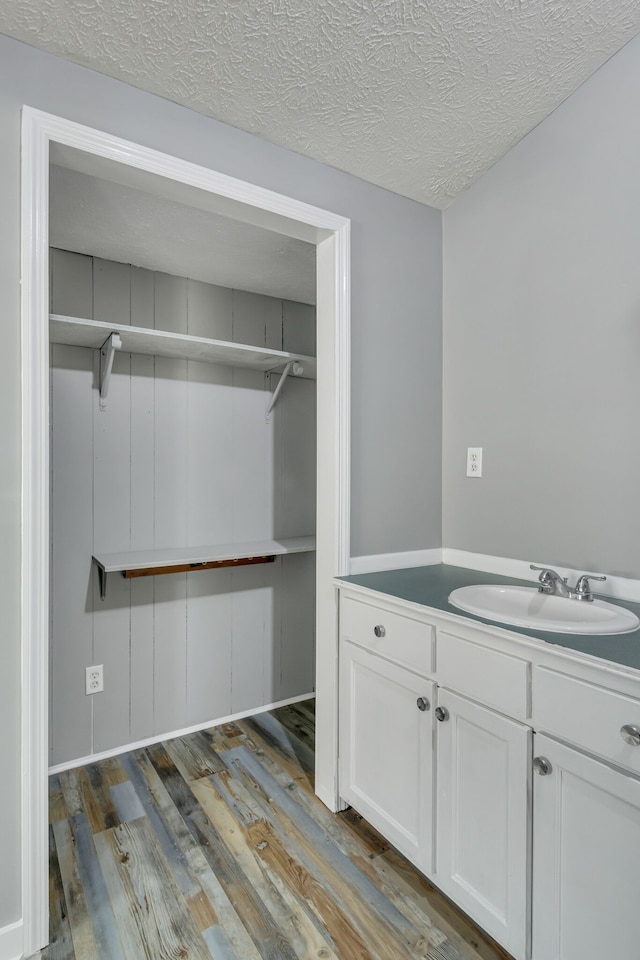 laundry room with dark hardwood / wood-style flooring, a textured ceiling, and sink