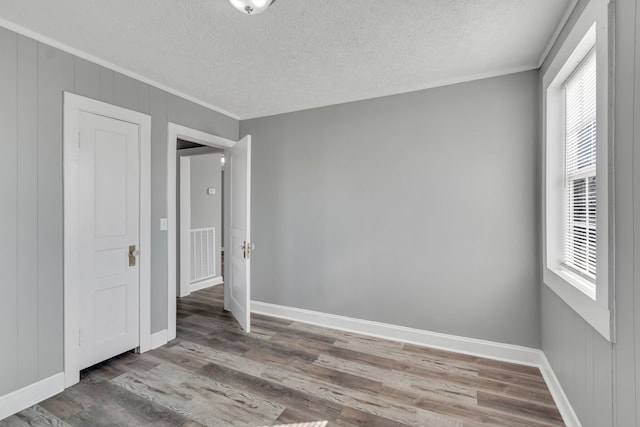 unfurnished room with a textured ceiling, dark hardwood / wood-style floors, and a healthy amount of sunlight