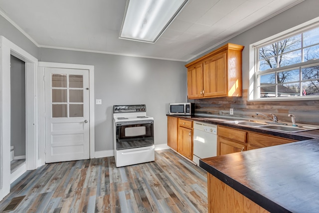 kitchen featuring tasteful backsplash, ornamental molding, light hardwood / wood-style flooring, white appliances, and sink