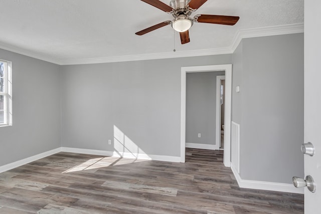 empty room featuring ornamental molding, ceiling fan, and dark hardwood / wood-style floors