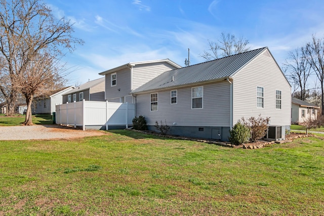 back of property with a yard and central AC