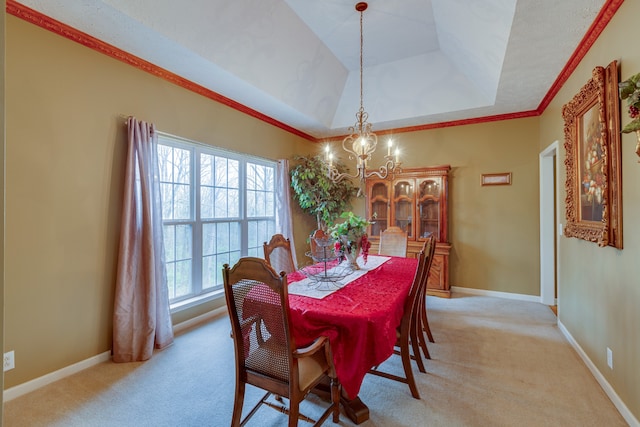 carpeted dining space with a raised ceiling, plenty of natural light, and a chandelier