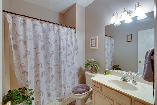 bathroom featuring toilet, a textured ceiling, and vanity