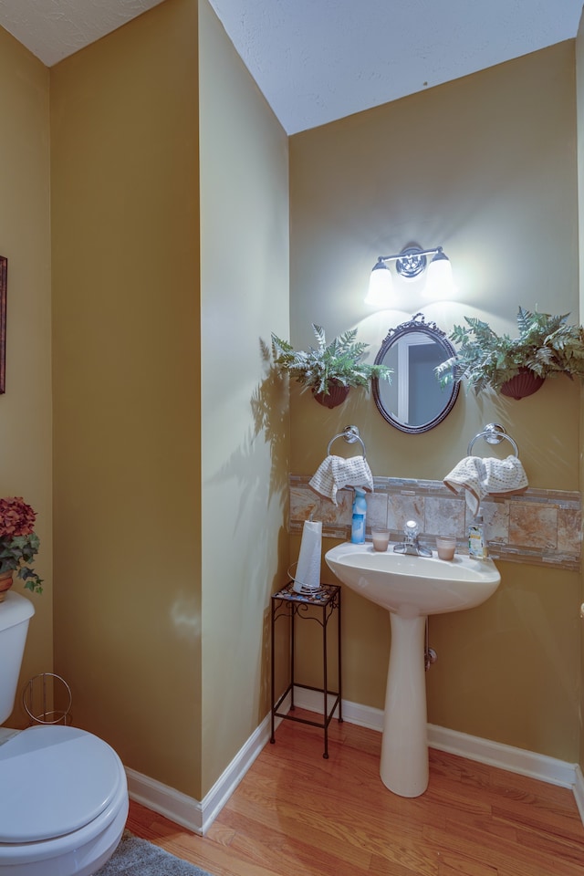 bathroom featuring hardwood / wood-style floors and toilet