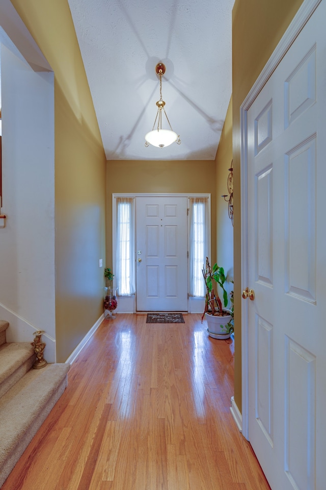 foyer with lofted ceiling and light wood-type flooring